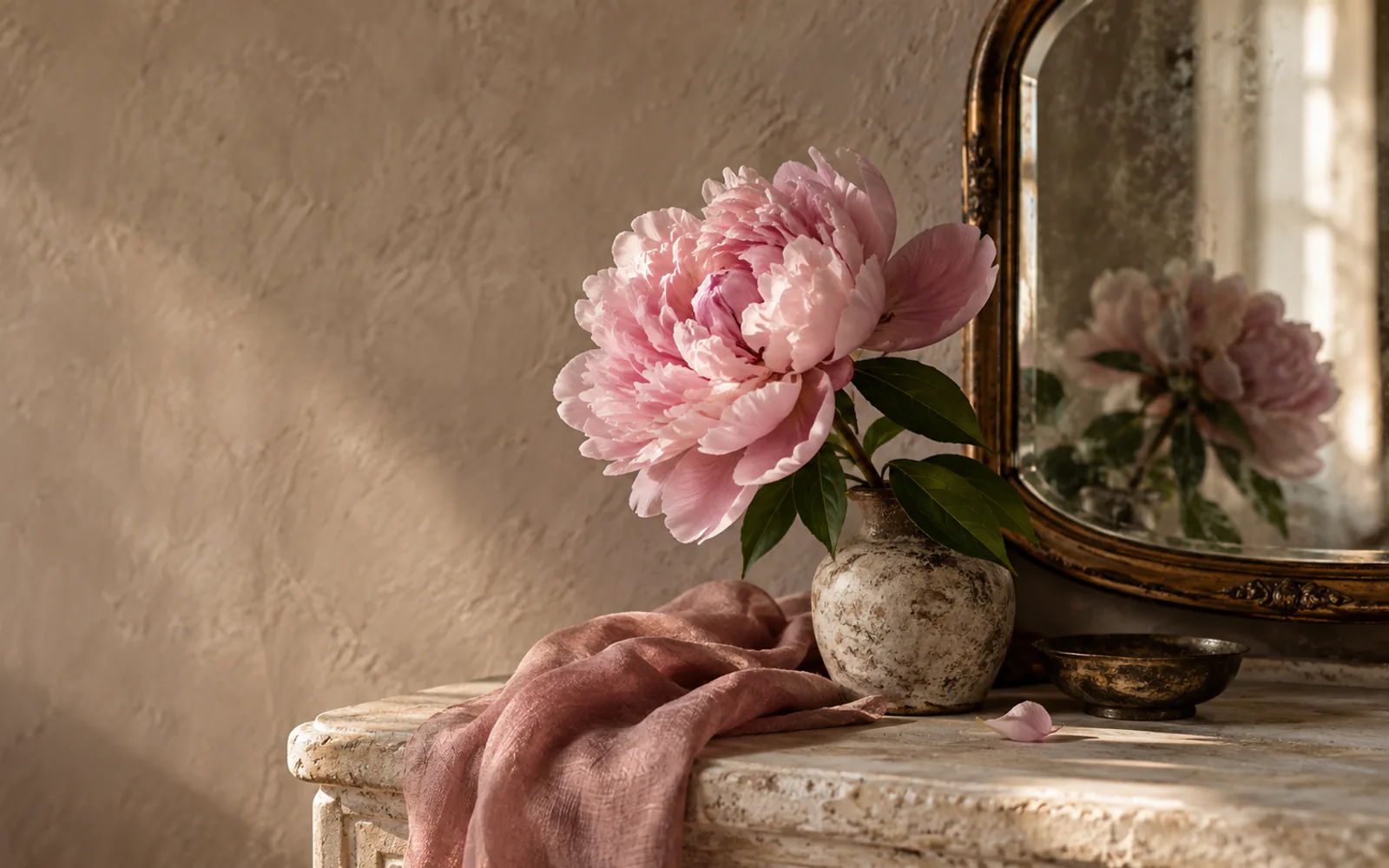 A pink peony beside a small mirror in warm window light.